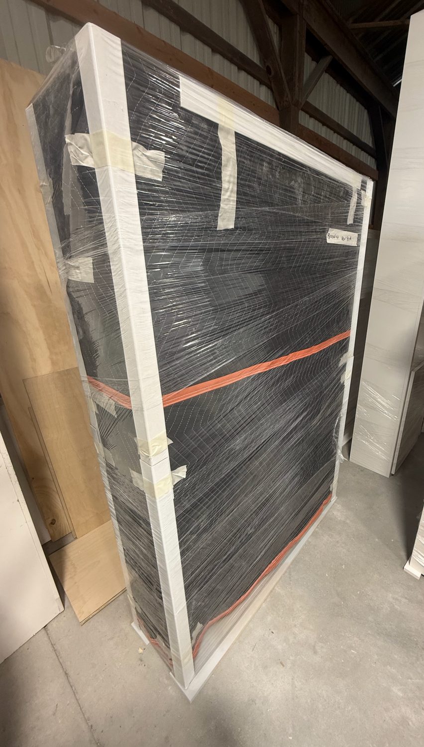 A Wooden Nest piece wrapped in plastic with cardboard corners, ready to ship