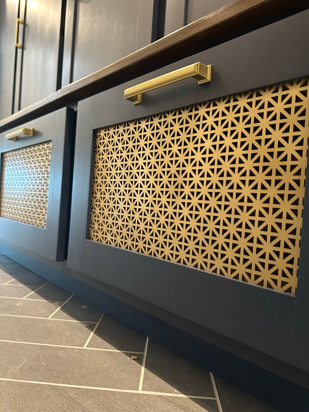 Close up of cane drawer fronts with a brass pull on the navy mudroom